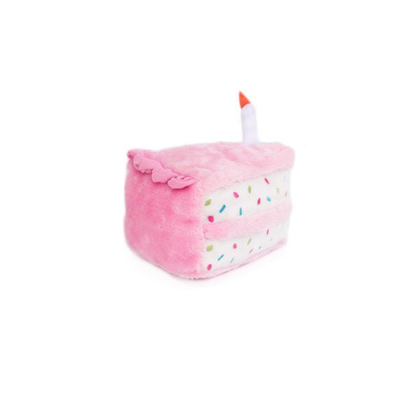 Pink plush toy shaped like a cake with a candle on a white background