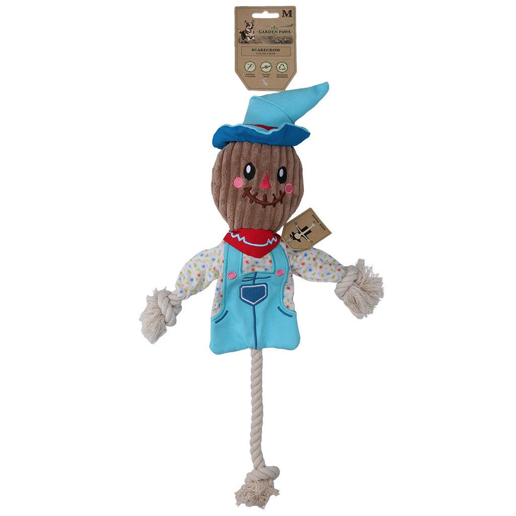 Scarecrow-shaped dog toy with a blue hat and vest on a white background
