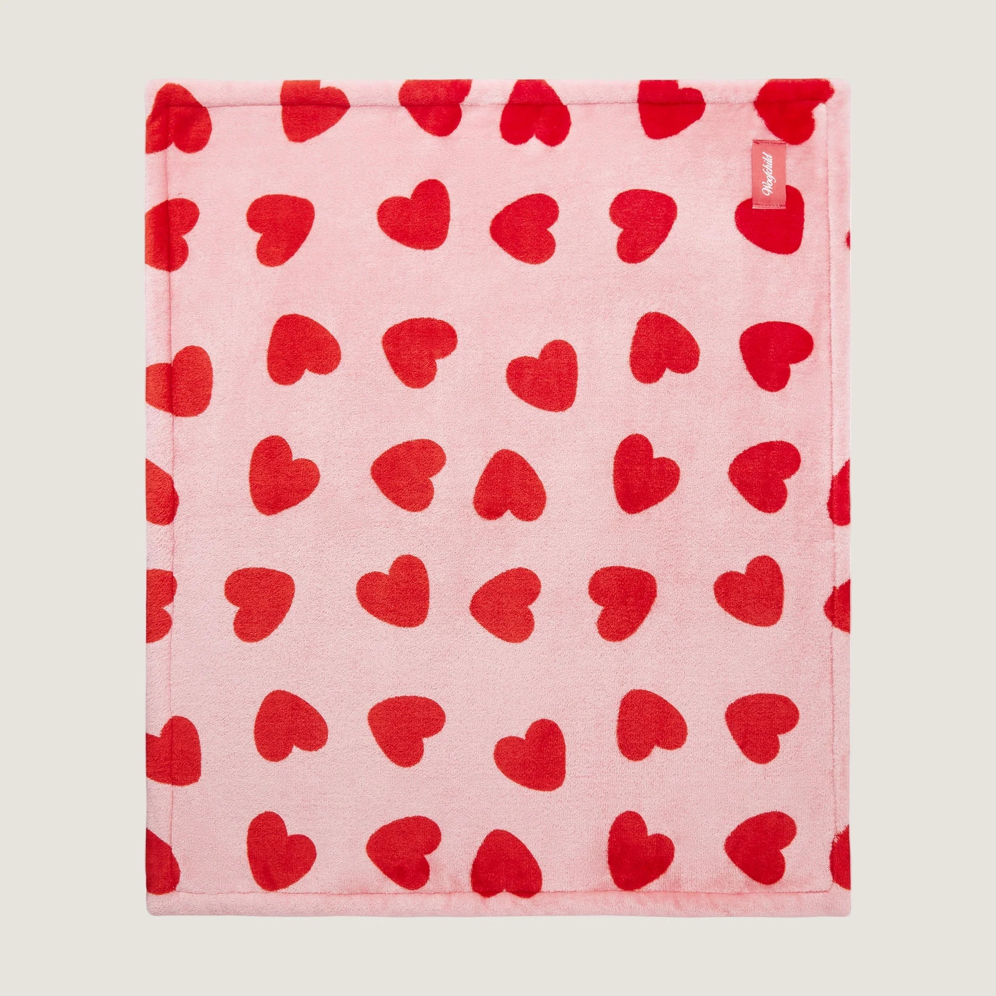 Serviette rose avec motif de cœur rouge sur fond rose clair