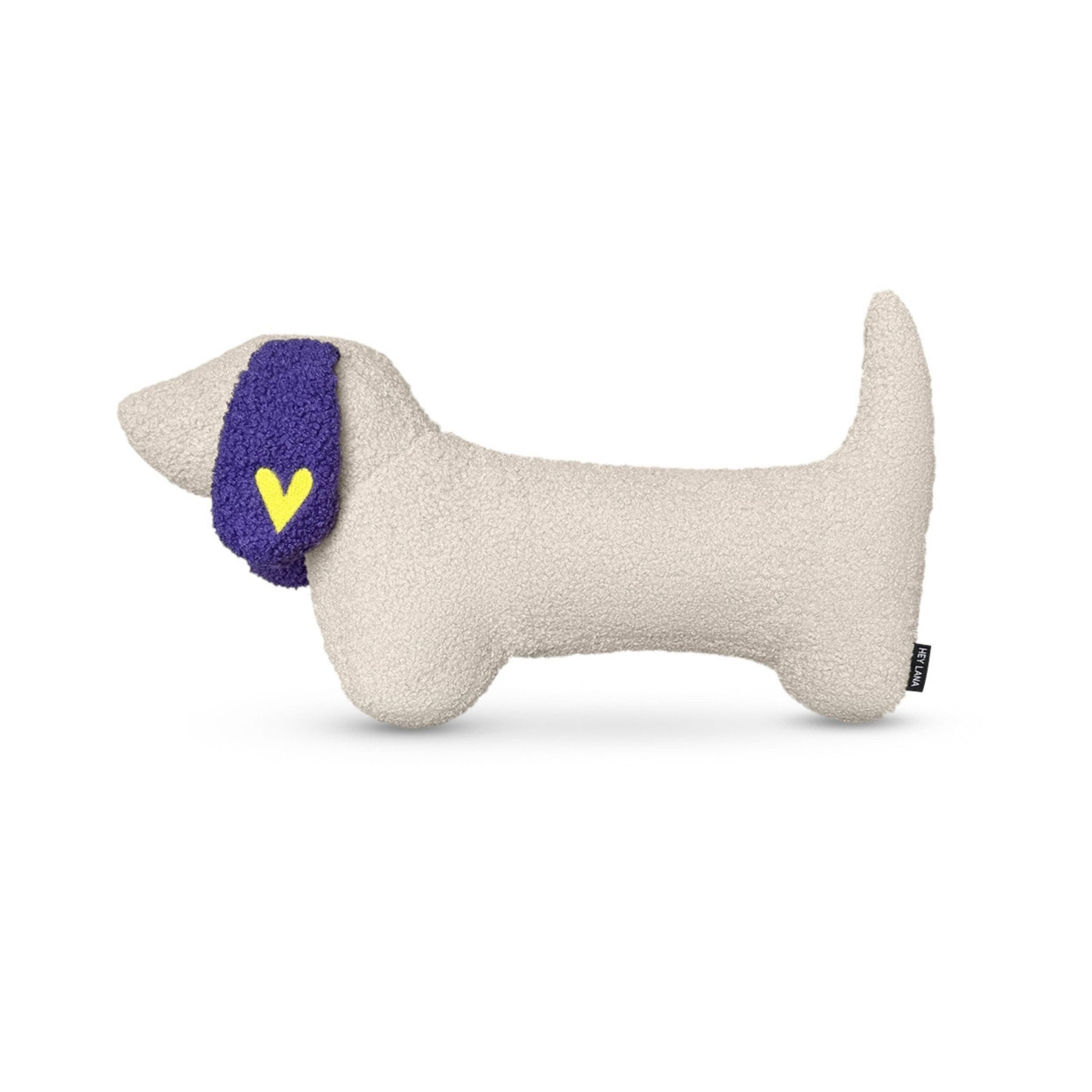 Coussin en forme de chien avec une oreille violette et un cœur jaune sur fond blanc