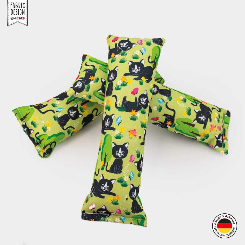 Three green catnip toys with black cat patterns on a white background