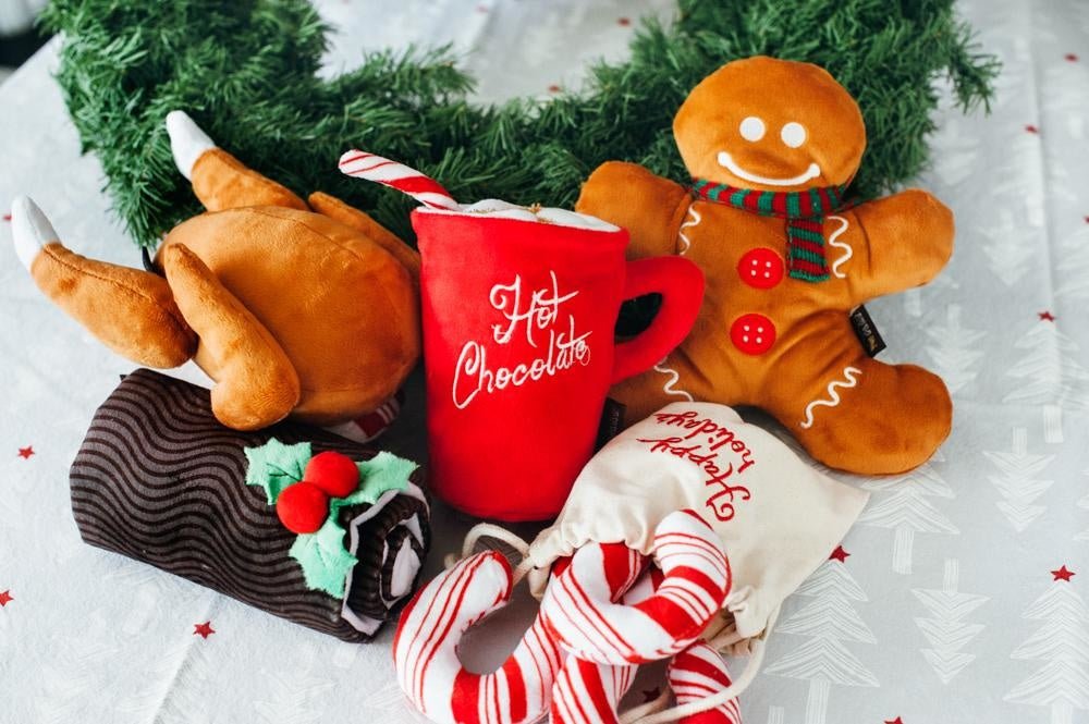 Christmas-themed plush toys including a turkey, gingerbread man, and hot chocolate mug on a white background with red stars.