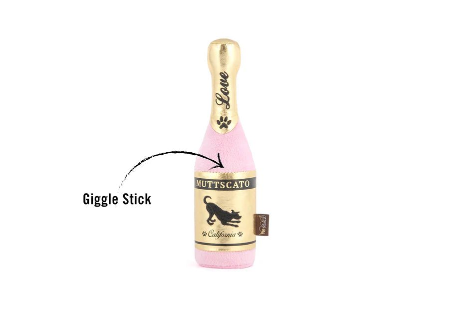 Dog toy shaped like a champagne bottle with a pink body and gold top on a white background.