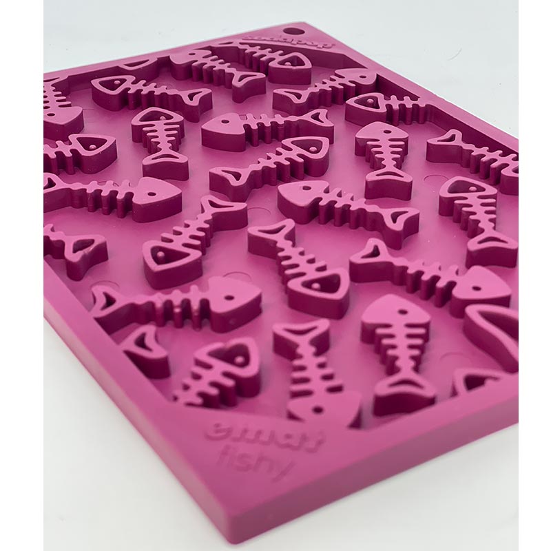 Pink silicone mold with fish bone shapes on a white background
