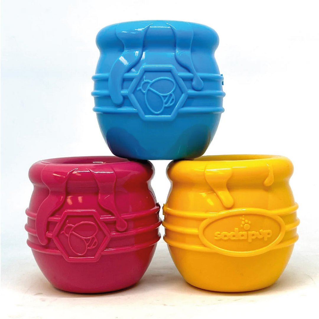 Three colorful plastic toys stacked on a white background, featuring the brand &
