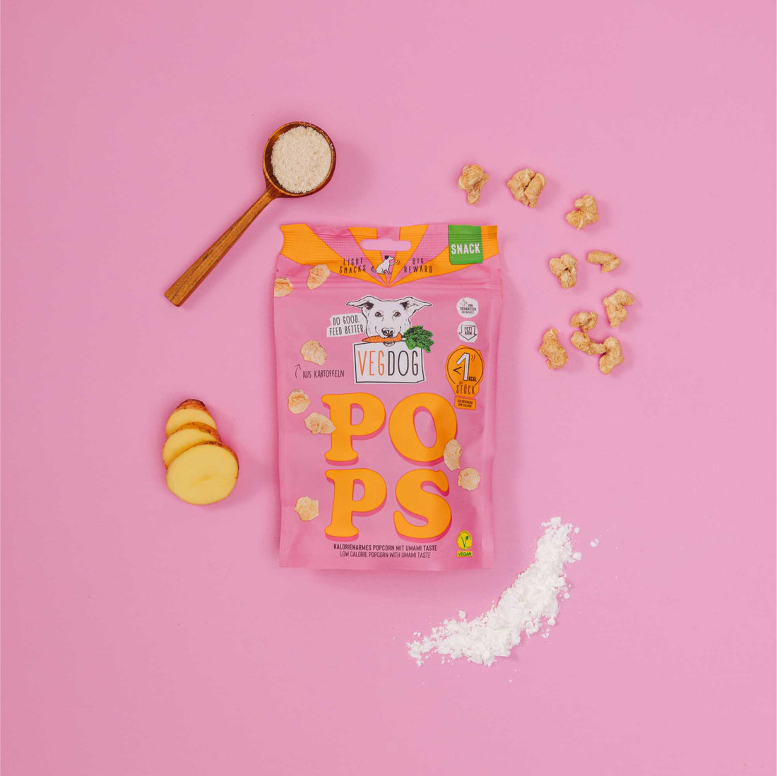 Veg Dog Pops packaging on a pink background with popcorn and a spoon.