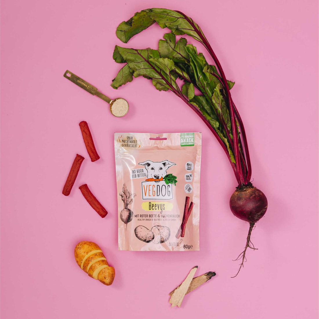 Veg Dog Beevs package with raw dog food ingredients on a pink background