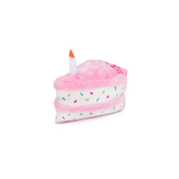 Pink toy cake with a candle on a white background