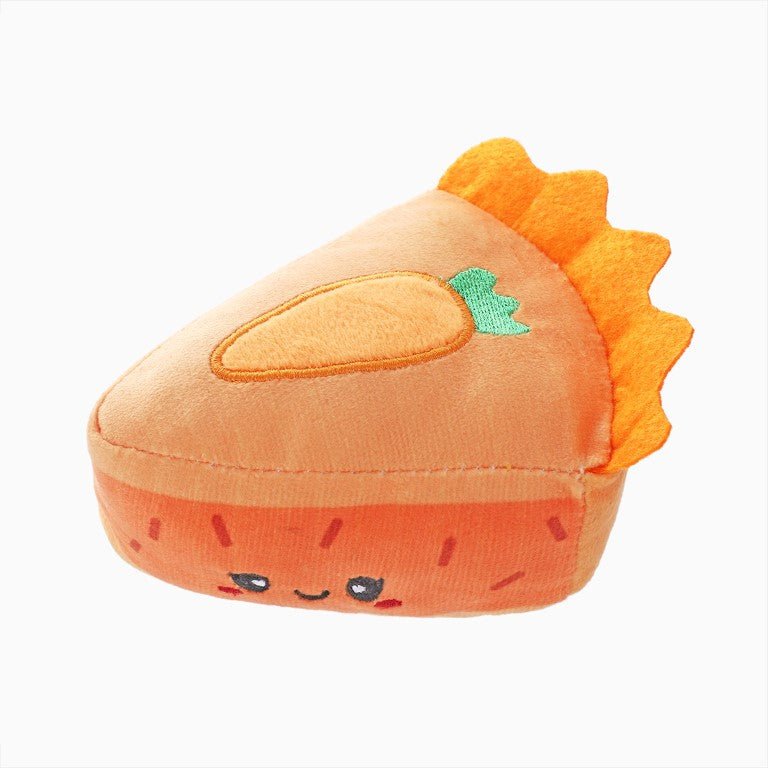 Plush carrot toy with a smiling face on a white background
