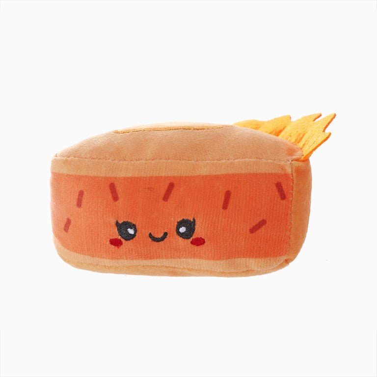 Plush toy shaped like a carrot with a face on a white background