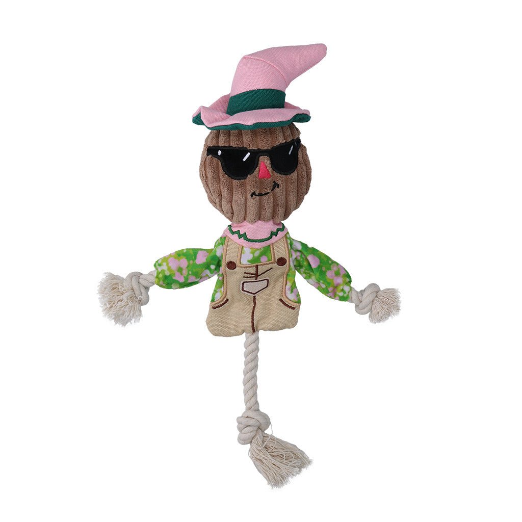 Toy scarecrow with sunglasses and a pink hat on a white background
