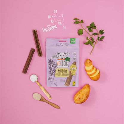 Vedog pet product packaging with treats and a spoon on a pink background