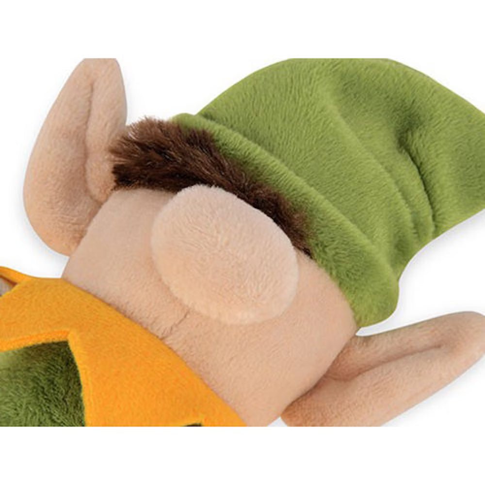 Close-up of a plush toy with green hat, brown ears, and orange outfit on a white background