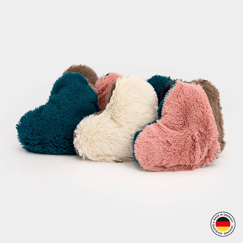 Set of fluffy heart-shaped slippers in teal, pink, and white on a light gray background.