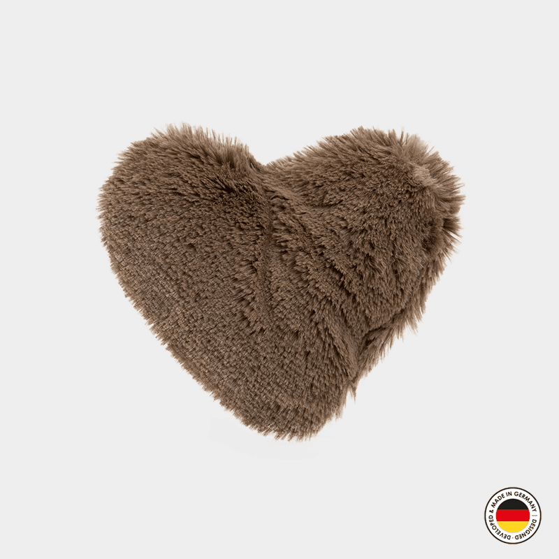 Brown fluffy heart-shaped pillow on a light gray background