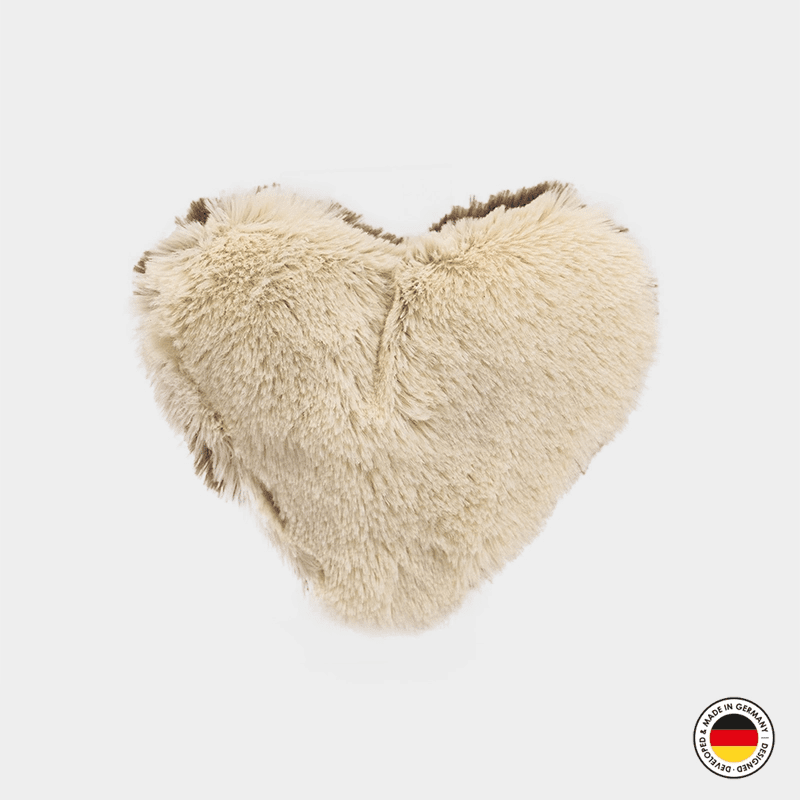 Heart-shaped fur pillow on a white background with a brand logo in the corner.
