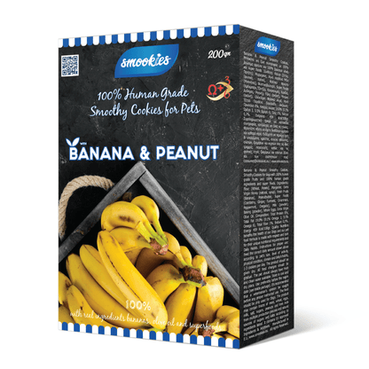 Æske med smookies banan- og jordnøddesmåkager til kæledyr på hvid baggrund