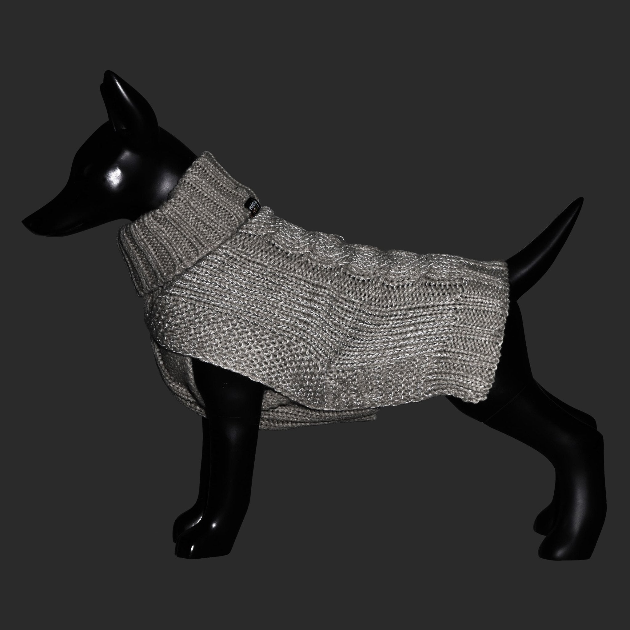 Dog wearing a gray knitted sweater on a black background