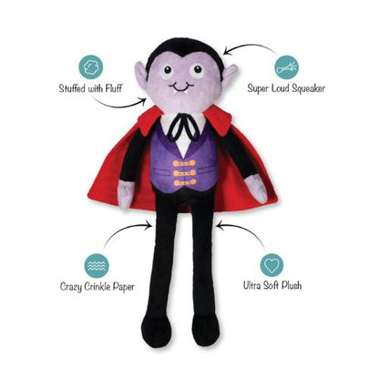 A vampire plush toy with a purple face, black hair and pants, a red cape, and a purple vest with gold buttons. Arrows point to the toy with feature callouts: &