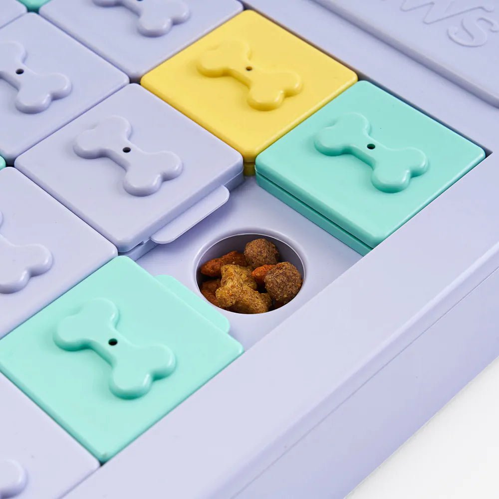 Colorful pet toy with bone-shaped compartments and a small container of dog treats.